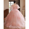A soft blush pink high end banquet style host floral tulle gown with puffy sleeves and layered floral appliqué skirt