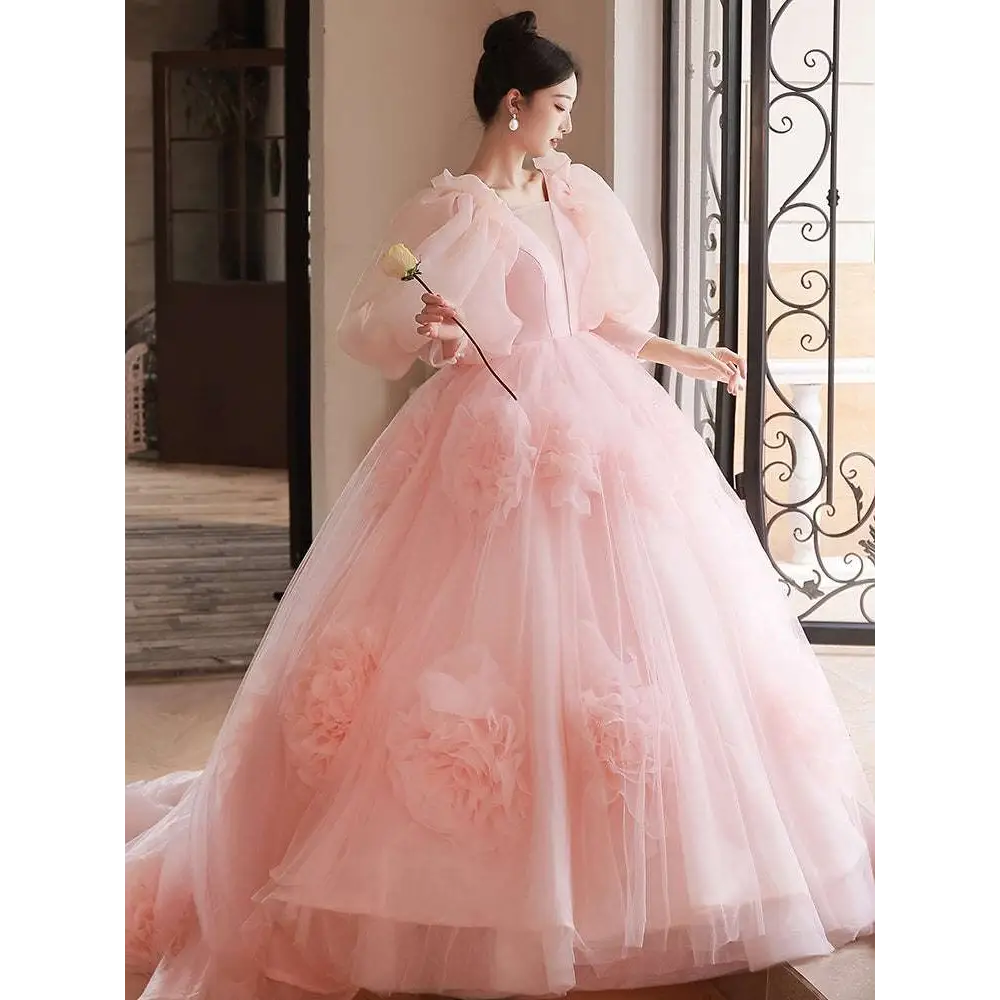 A soft pink high end banquet style host floral tulle gown with voluminous ball gown skirt and puffy sleeves