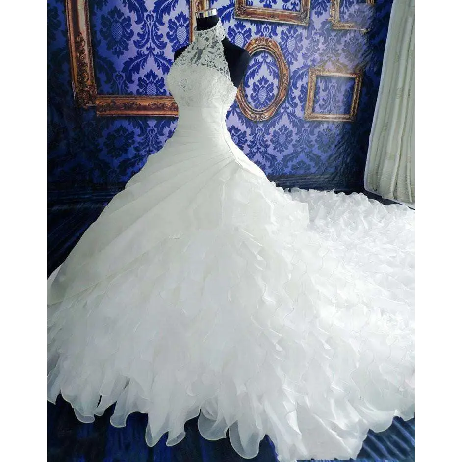 A voluminous white wedding dress wholesale featuring a fitted bodice and ruffled big tail layered skirt