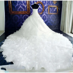 A voluminous white wedding dress wholesale featuring a fitted bodice and ruffled big tail layered skirt