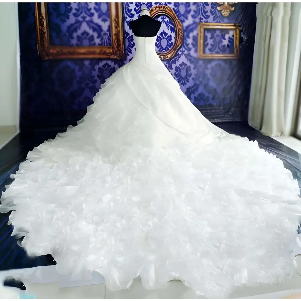 A voluminous white wedding dress wholesale featuring a fitted bodice and ruffled big tail layered skirt