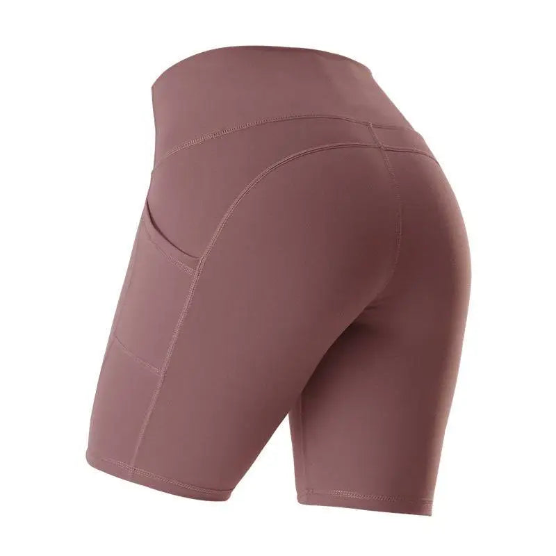 A pair of high waist fitness athletic yoga pants in mauve with a sleek fit and side pockets for gym use