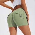 Mint green high-waisted workout shorts with a buttoned flap pocket and side pockets.