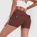 Brown high waist hip lifting shorts with fitted waistband and buttoned side pockets in a sleek form-fitting design