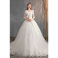 White lace wedding dress with high waist, sheer three-quarter sleeves, embroidered bodice, and trailing skirt