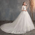 A white high waist lace wedding dress trailing with three-quarter sleeves and floral embroidery on bodice and hemline