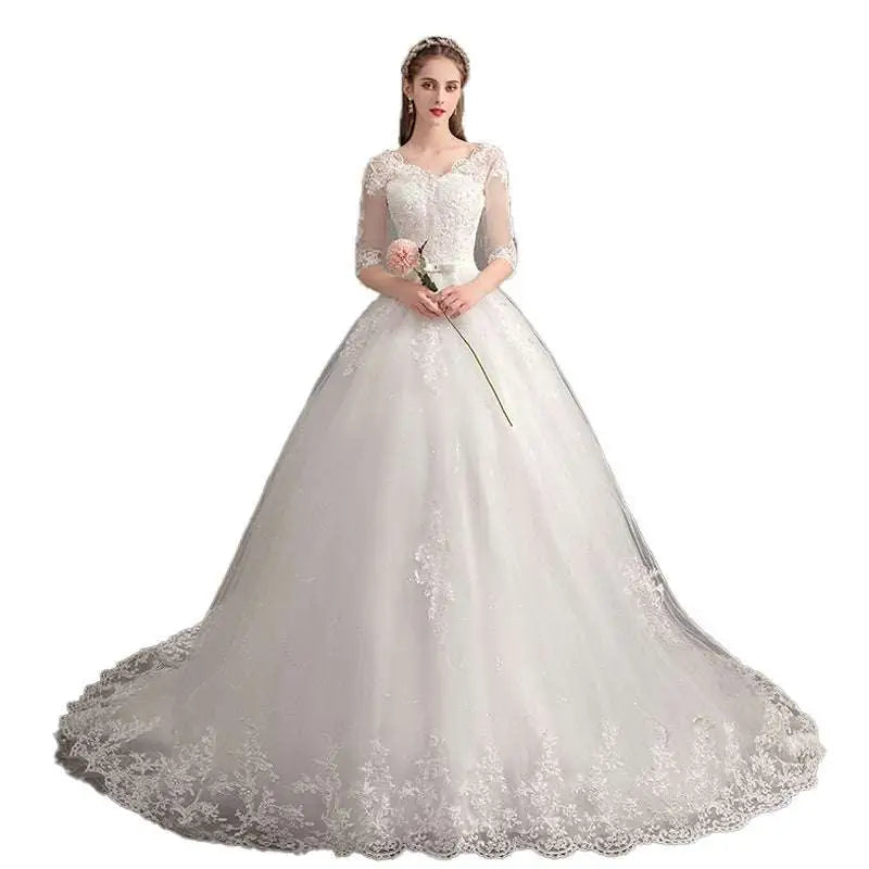 Elegant white lace wedding dress with high waist design and trailing ballgown silhouette featuring three-quarter sleeves