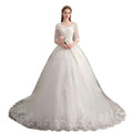 Elegant ivory lace wedding dress with intricate lace detailing high waist and trailing design, three-quarter sleeves