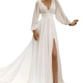 A flowing white long sleeve backless wedding dress with a deep v-neckline and high slit for elegant occasions