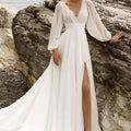 A flowing white wedding dress with long sheer sleeves high slit and backless design perfect for elegant occasions