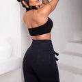 Black high waist metallic belt skinny pants showing side zipper and back pockets from the back side view