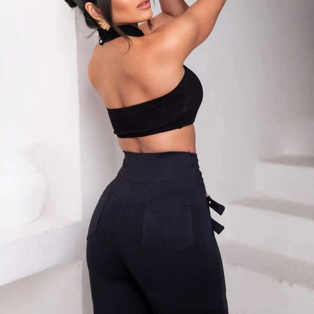 Black high waist metallic belt skinny pants showing side zipper and back pockets from the back side view