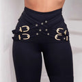 Black high waist leggings with a metallic belt skinny design featuring gold d-shaped buckles and circular eyelets