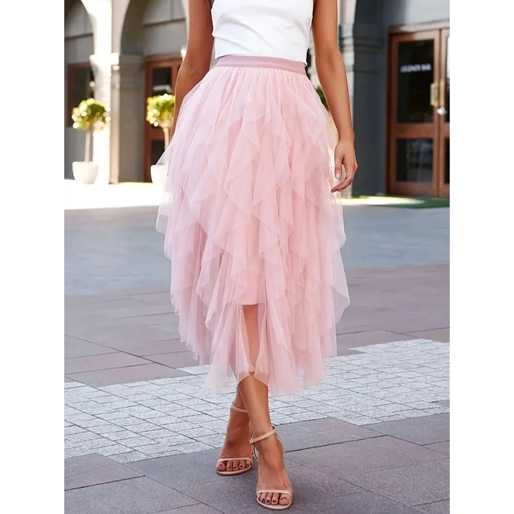 A flowing light pink high waist tiered slimming mesh skirt with matching waistband made of tulle fabric