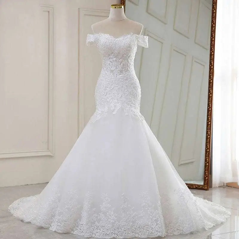 High waist white lace mermaid wedding dress with off-the-shoulder neckline and flowing tulle skirt in white lace mermaid style