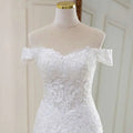 A white lace mermaid wedding dress with off-the-shoulder neckline intricate lace detailing and sparkling beading