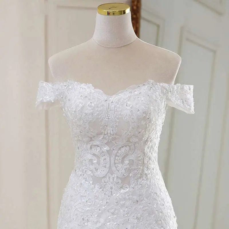 A white lace mermaid wedding dress with off-the-shoulder neckline intricate lace detailing and sparkling beading
