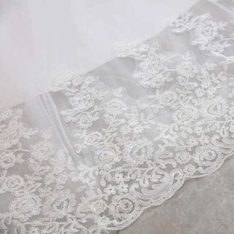 High waist white lace mermaid wedding dress featuring delicate embroidered floral lace trim with scalloped edges