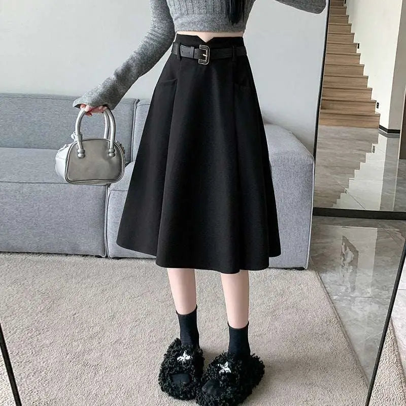 Black high waist woolen umbrella skirt with matching belt and front pockets in a-line design