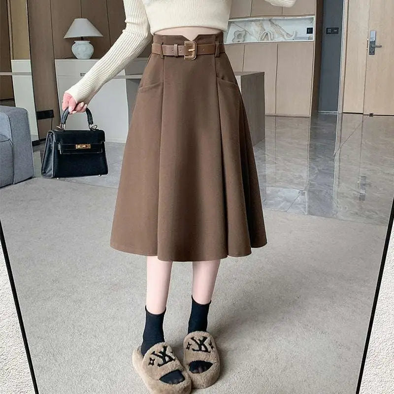 Brown high waist woolen umbrella skirt with pleats and matching belt featuring a gold toned buckle