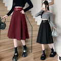 A flared burgundy woolen umbrella skirt with a structured brown high waist and matching belt at mid-thigh length
