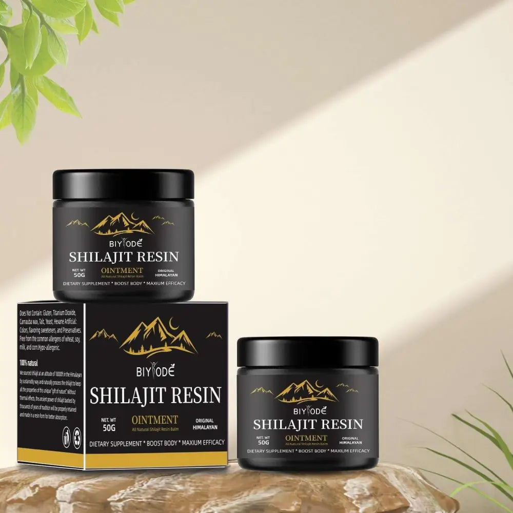 Black cylindrical jar of biyode shilajit resin ointment with gold mountain logo beside its box for himalayan shilajit gummies