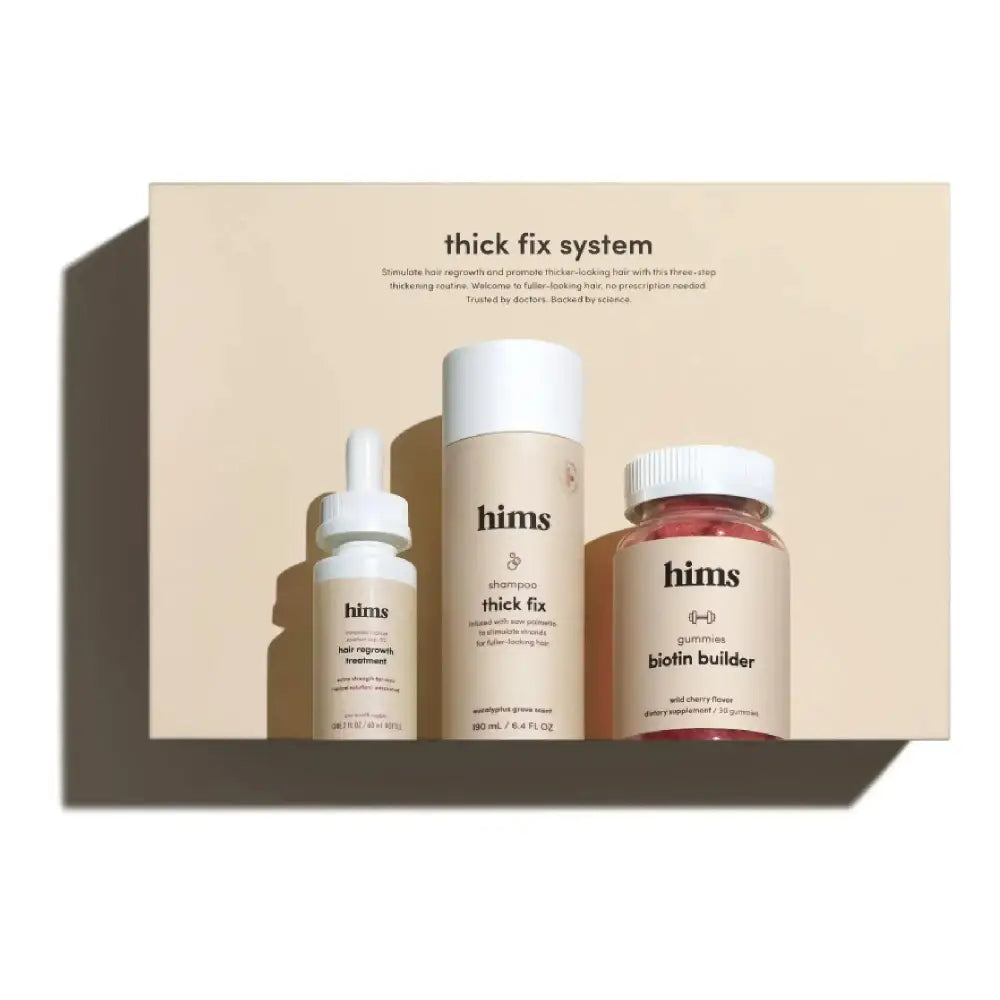 The hims total hair revival kit includes a beige thickening shampoo canister, dropper bottle, and pink gummy jar
