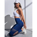 White athletic cap with black embroidered logo paired with high-waisted hollow seamless yoga pants with mesh panels