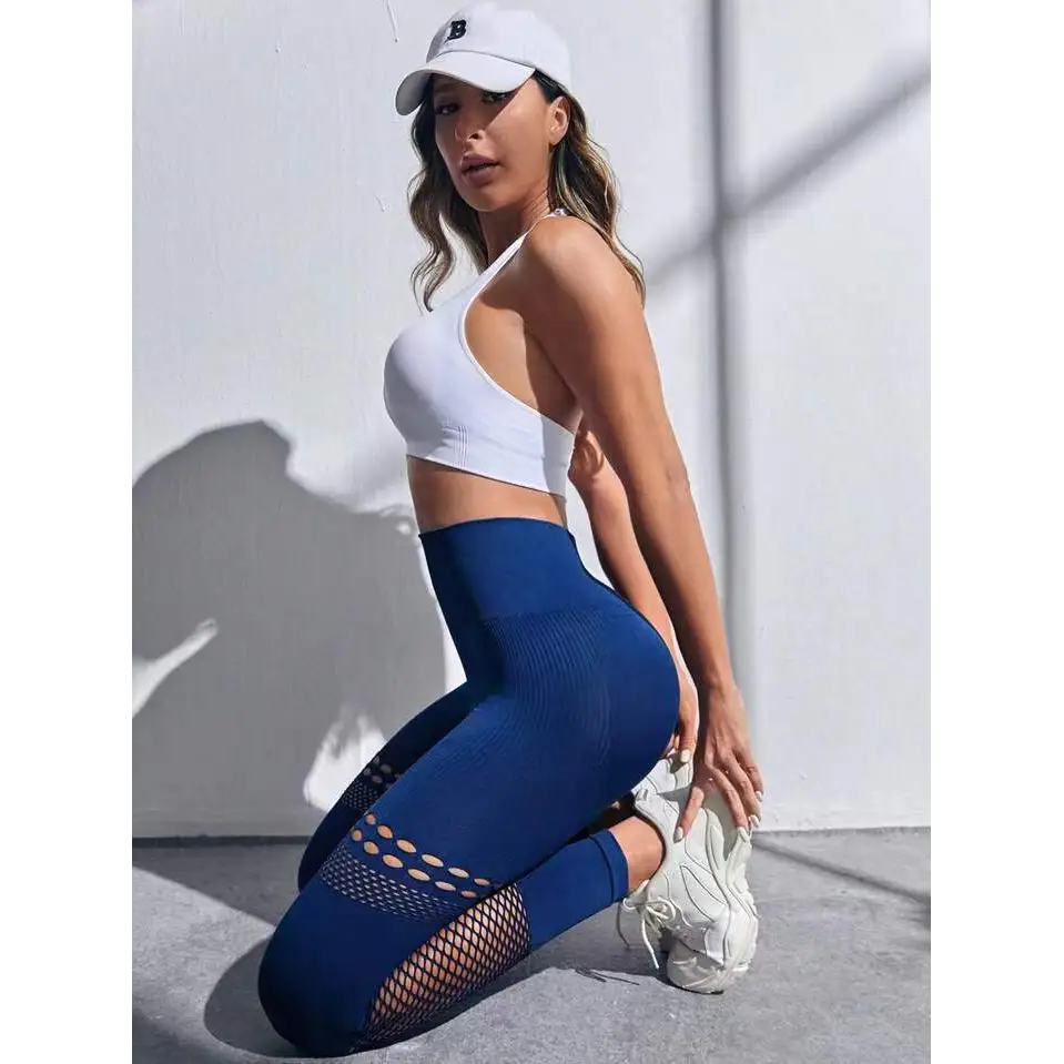 White athletic cap with black embroidered logo paired with high-waisted hollow seamless yoga pants with mesh panels