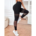 Black high-waisted hollow seamless yoga pants with mesh panels and cut-out details for training and workouts