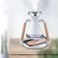White and wood-handled humidifier usb wireless glass aroma diffuser with glass tank emitting mist and charging smartphone