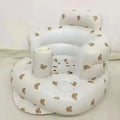 White inflatable baby chair with beige bear face patterns designed for dining and bath use