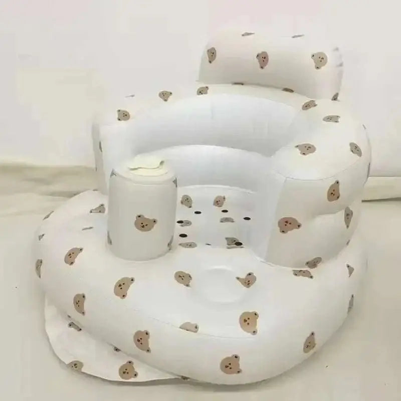 White inflatable baby chair with beige bear face patterns designed for dining and bath use