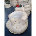 Inflatable baby chair with soft white exterior featuring pink cartoon animals and clear plastic lining for dining and bath use