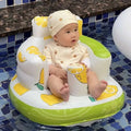 A baby sits in a white and lime green inflatable baby chair with yellow lemon design and soft padding for comfort