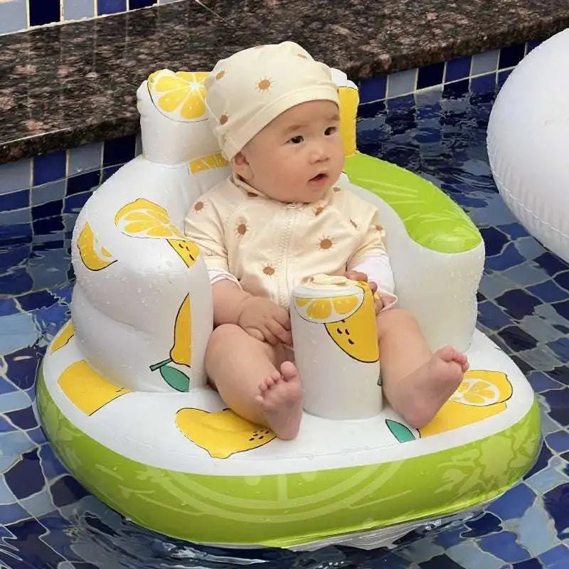 A baby sits in a white and lime green inflatable baby chair with yellow lemon design and soft padding for comfort