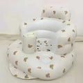 White inflatable baby chair with beige bear face patterns designed for dining and bath use