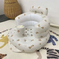 White inflatable baby chair with soft cushioned design and beige teddy bear pattern for dining and bath use
