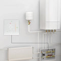 White intelligent home heating digital thermostat switch displaying 25°c mounted on wall near heating components