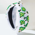 White knotted headband with irish green shamrock rhinestone charms and emerald rhinestones in gold-tone settings