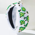 White knotted headband featuring irish green shamrock rhinestone charms and emerald rhinestones in gold settings
