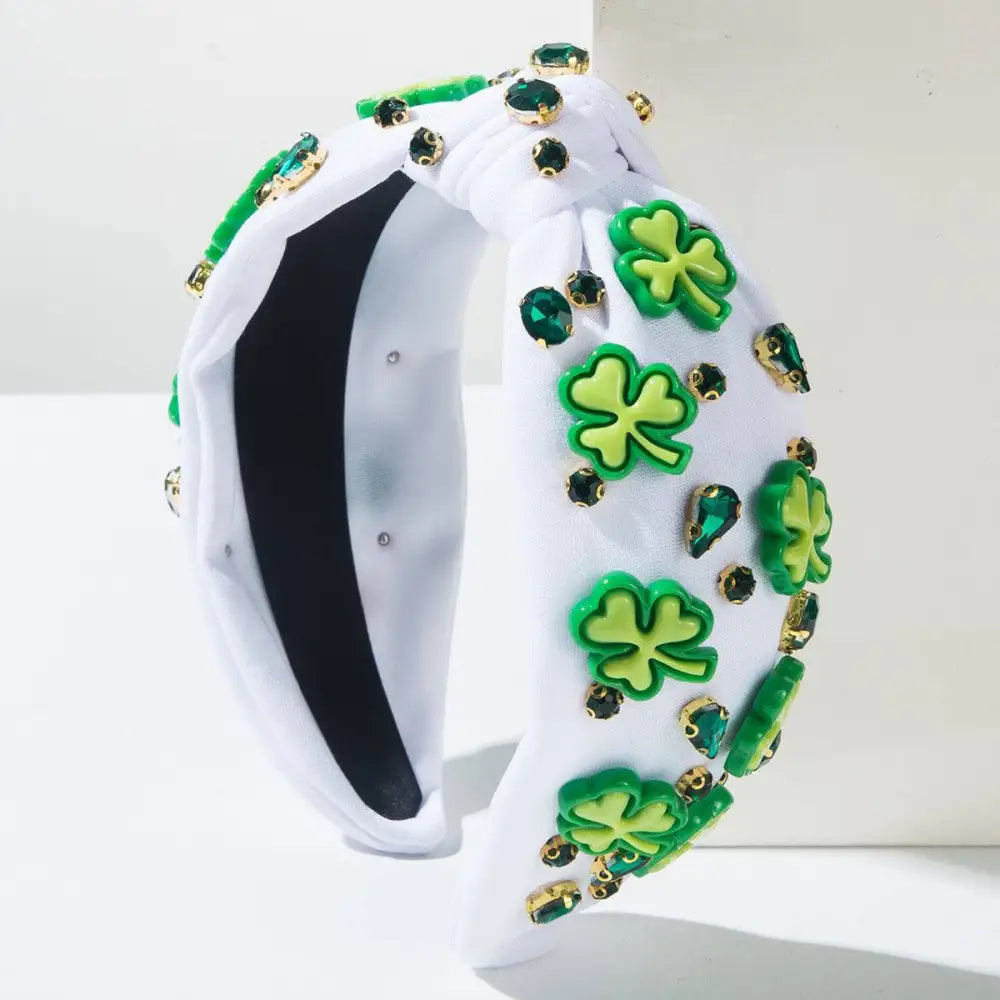 White knotted headband featuring irish green shamrock rhinestone charms and emerald rhinestones in gold settings