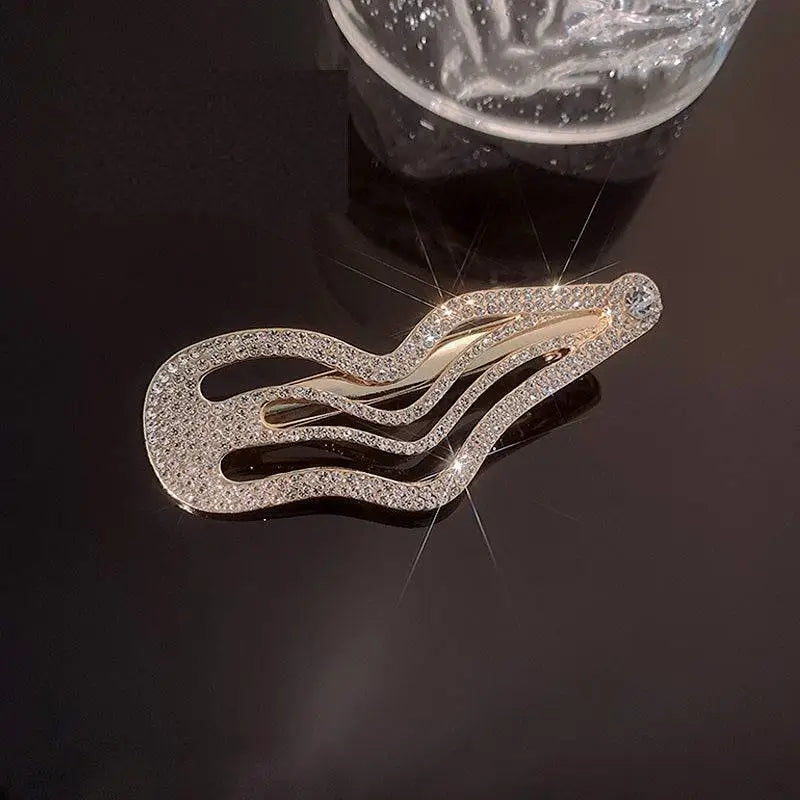 A gold-toned irregular lines bang sweet cool rhinestone hair clip with sparkling clear crystals in a wavy design