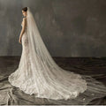 A flowing ivory lace bridal church wedding veil with delicate floral embroidery and a sheer pearl long tail design