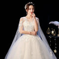 Elegant ivory lace wedding dress featuring intricate lace appliqués and a flowing sheer capelet veil