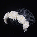 Elegant ivory satin rose hair hoop headdress adorned with pearls silver feather accents and delicate mesh veil for weddings