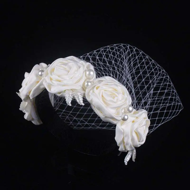 Elegant ivory satin rose hair hoop headdress adorned with pearls silver feather accents and delicate mesh veil for weddings