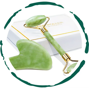 Green jade facial roller and matching gua sha massage tool with gold-toned accents in a jade rolling and sha gift set
