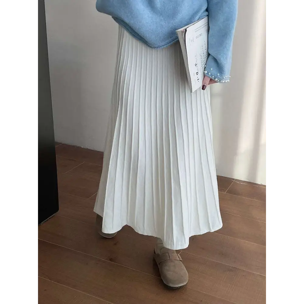 A flowing white korean elastic waist knitted pleated midi skirt made of soft lightweight fabric that drapes elegantly