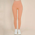 A pair of peach-colored korean fashion high waisted bow yoga pants made of smooth stretchy fabric
